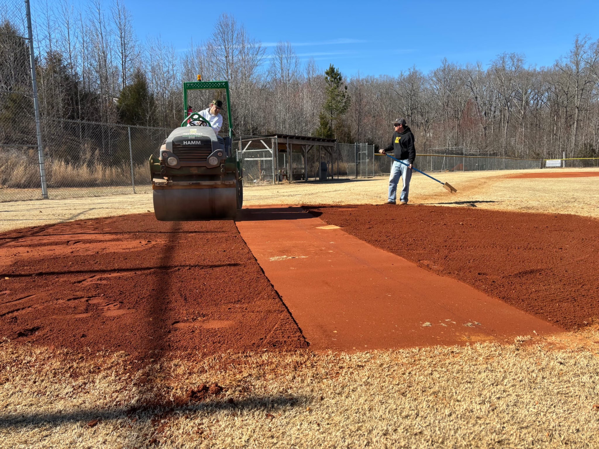Rolling and dressing a ballfield infield